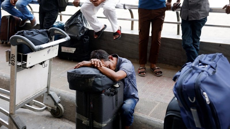 Travelers with luggage at an airport, representing Indian students whose exams were disrupted by conflict in West Asia