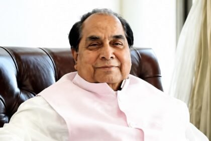 Portrait of Dr. D. Y. Patil, an elderly man in white traditional attire, seated in a maroon armchair
