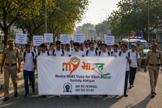 Young participants marching with a "Nasha Mukt Yuva" anti-drug campaign banner, flanked by police