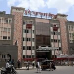 Exterior of the Pune Municipal Corporation building with people and vehicles outside