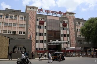 Exterior of the Pune Municipal Corporation building with people and vehicles outside