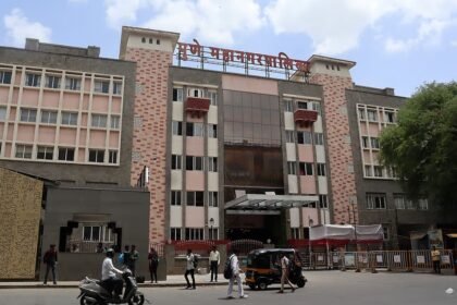 Exterior of the Pune Municipal Corporation building with people and vehicles outside
