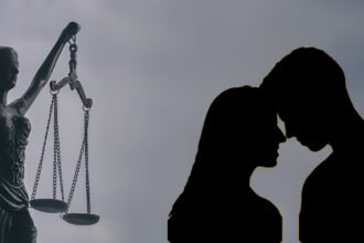 Lady Justice statue beside a silhouette of a couple standing close together, symbolizing a live-in relationship case