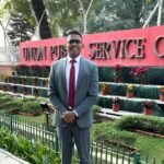 Adv. Sunil Kadam in a suit standing in front of the Union Public Service Commission building sign