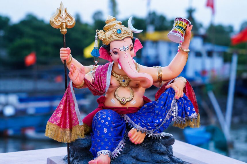 सजवलेल्या गणेशमूर्तीच्या मुखाचे क्लोजअप छायाचित्र, उत्सवी पार्श्वभूमी