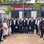 Group of lawyers in black coats standing in front of the Lonikand Police Station
