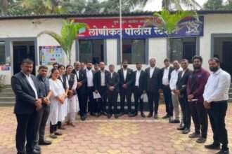 Group of lawyers in black coats standing in front of the Lonikand Police Station