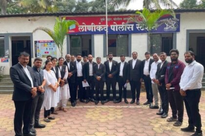 Group of lawyers in black coats standing in front of the Lonikand Police Station
