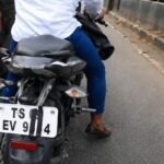 A scooter parked roadside with its rear number plate clearly visible