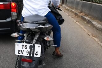 A scooter parked roadside with its rear number plate clearly visible