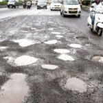 पुण्यातील खड्डेमय रस्त्यावरून वाहन चालवताना कार व दुचाकीस्वार