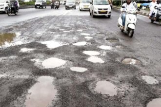 पुण्यातील खड्डेमय रस्त्यावरून वाहन चालवताना कार व दुचाकीस्वार