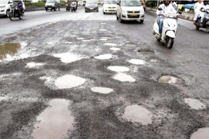 पुण्यातील खड्डेमय रस्त्यावरून वाहन चालवताना कार व दुचाकीस्वार