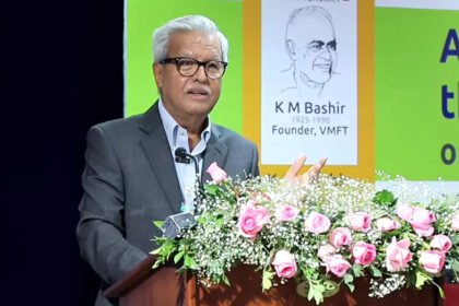 Adv. Dushyant Dave speaking at a podium during the K.M. Bashir Memorial Lecture, with a stage backdrop showing a portrait of K.M. Bashir (1925–1990) and the lecture's title displayed on screen.