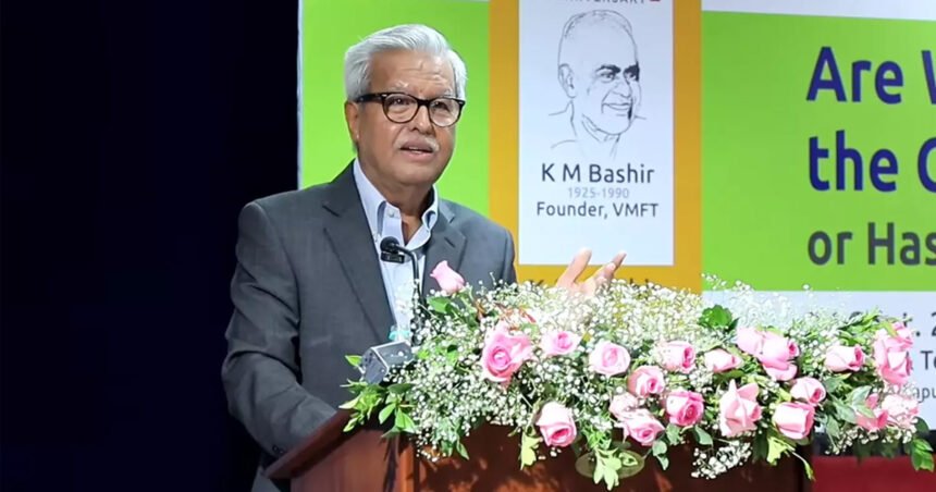 Adv. Dushyant Dave speaking at a podium during the K.M. Bashir Memorial Lecture, with a stage backdrop showing a portrait of K.M. Bashir (1925–1990) and the lecture's title displayed on screen.