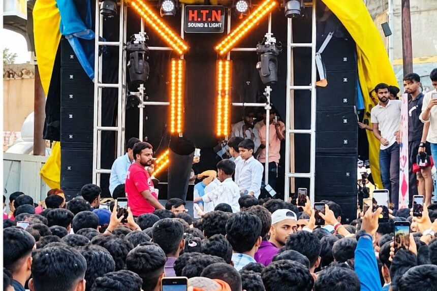 मोठा डीजे मंच व प्रकाशयोजना असलेला परिसर, समोर जमलेली गर्दी