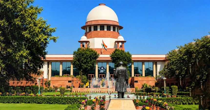 भारताच्या सर्वोच्च न्यायालयाची इमारत, पांढरा घुमट आणि लाल दगडी बांधकाम, वर तिरंगा ध्वज, निरभ्र निळ्या आकाशाच्या पार्श्वभूमीवर