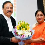 शपथविधी समारंभात औपचारिक पोशाखातील न्यायमूर्ती त्रिपाठी आणि शेजारी बसलेल्या महिला मान्यवर