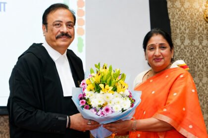 शपथविधी समारंभात औपचारिक पोशाखातील न्यायमूर्ती त्रिपाठी आणि शेजारी बसलेल्या महिला मान्यवर