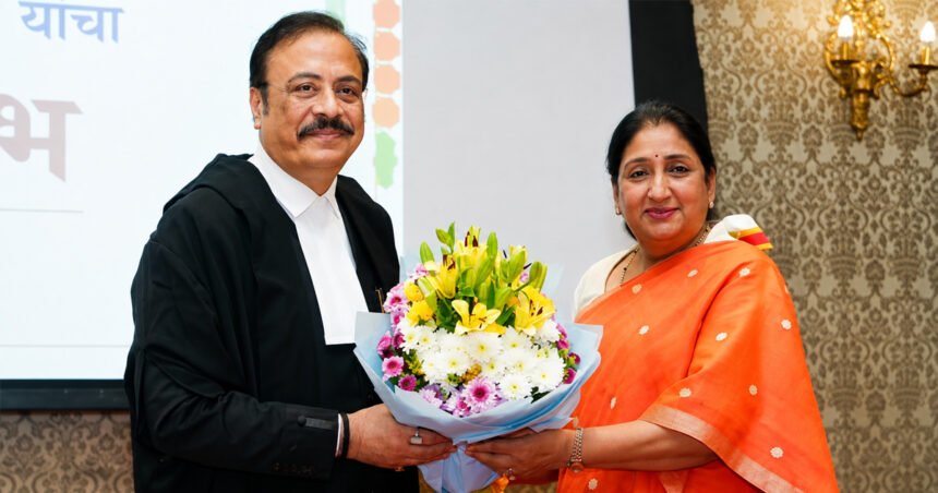शपथविधी समारंभात औपचारिक पोशाखातील न्यायमूर्ती त्रिपाठी आणि शेजारी बसलेल्या महिला मान्यवर